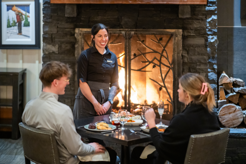 Silvertip Rustica dining couple with fireplace and server